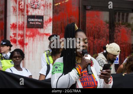 Londra, Regno Unito. 27 agosto 2021. Marvina Newton si rivolge agli attivisti ambientali della ribellione dell'estinzione dopo che la vernice rossa di sangue è stata spruzzata sull'ala nord della Guildhall durante una marcia Blood Money attraverso la città di Londra. Extinction Rebellion intendevano evidenziare le istituzioni finanziarie che finanziavano progetti sui combustibili fossili, soprattutto nel Sud del mondo, così come gli studi legali e le istituzioni che li agevolano, mentre chiedevano al governo britannico di cessare tutti i nuovi investimenti sui combustibili fossili con effetto immediato. Credit: Mark Kerrison/Alamy Live News Foto Stock