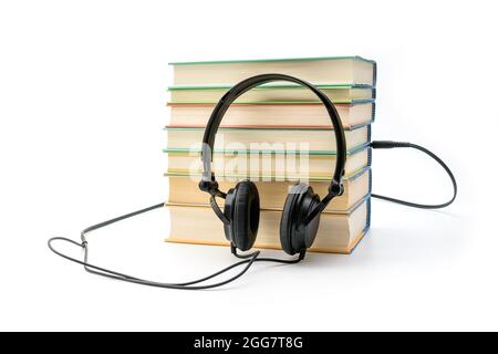 Pila di libri con le cuffie. Audiolibri. Ascoltare e studiare il concetto Foto Stock
