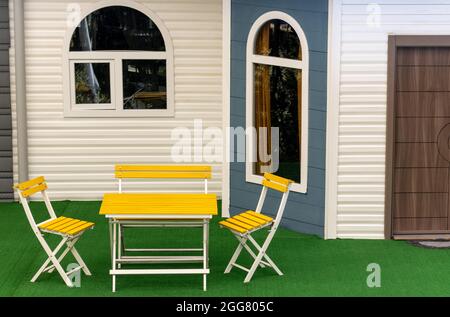 Due sedie gialle di fronte ad una casa esterna Foto Stock