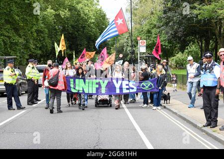 Londra, Regno Unito. 29 agosto 2021. I manifestanti hanno una bandiera e marciano a Finsbury Park per un raduno al Carnevale della Rebellion di estinzione per la giustizia climatica a Londra parte delle loro due settimane di proteste di ribellione impossibile.XR Unify è un BIPOC-diretto (nero, indigeno e gente di colore) gruppo che si sta facendo per porre fine all’industria dei combustibili fossili. (Foto di Dave Rushen/SOPA Images/Sipa USA) Credit: Sipa USA/Alamy Live News Foto Stock