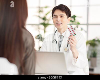 Medico mostrante con pillole al paziente. Foto Stock