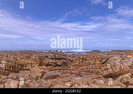 Paesaggio di aspra costa rocciosa del Parco Nazionale di Capo Agulhas in Sud Africa che è il punto più meridionale del continente africano. Foto Stock