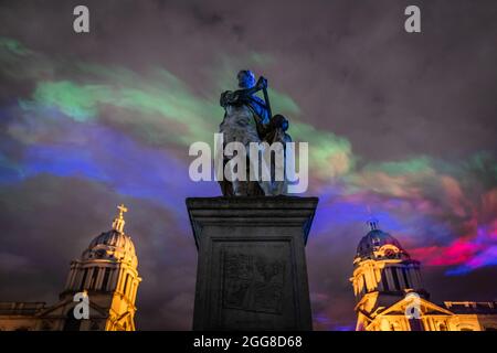 'Borealis' dell'artista Dan Acher illumina il cielo notturno in sfumature colorate astratte sull'Old Royal Naval College come parte del Greenwich + Docklands International Festival. Foto Stock