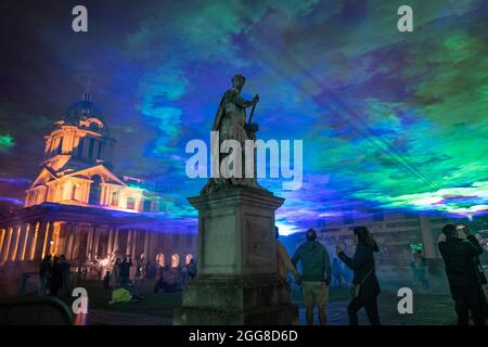 'Borealis' dell'artista Dan Acher illumina il cielo notturno in sfumature colorate astratte sull'Old Royal Naval College come parte del Greenwich + Docklands International Festival. Foto Stock