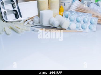 Set di medicazioni per la cura delle ferite. Pinzette, bastone di cotone, bendaggio conforme, bendaggio elastico di ritenzione coesiva, batuffolo di cotone con alcool, guanti monouso in lattice Foto Stock