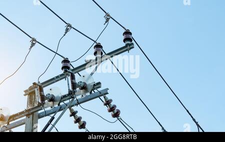 Alimentazione elettrica trifase per il trasferimento di potenza da reti elettriche. Energia elettrica per sostenere l'industria manifatturiera. Poli elettrici ad alta tensione Foto Stock