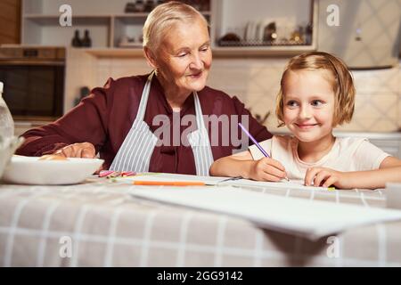 Capretto gioioso che ottiene l'idea per l'immagine mentre siede con nonna Foto Stock