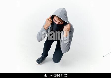 uomo mascherato agganciato nascondendo il suo furto di faccia Foto Stock