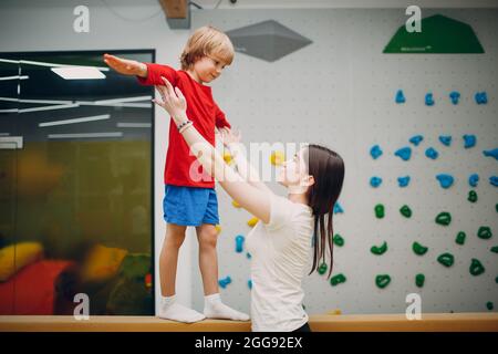 I bambini che fanno esercizi di ginnastica con fascio bilanciato in palestra presso l'asilo o la scuola elementare. Concetto di sport e fitness per bambini Foto Stock