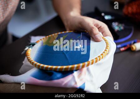 Processo di ricamo a mano donna in tessuto di seta per un nuovo abito con perline Foto Stock