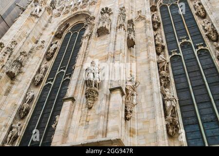 Un dettaglio, da vicino di una delle tante statue sacre, di angeli, sculture sulla facciata della chiesa cattolica, cattedrale, Duomo. A Milano. Foto Stock