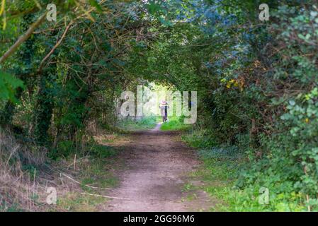 Public Byway Y23 fuori Bath Road Longford vicino all'aeroporto di Heathrow, Regno Unito, un'area verde di percorso con l'autostrada M25. Lavoro pendolari in bicicletta in traforo albero Foto Stock