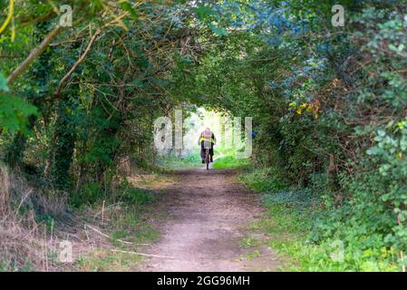 Public Byway Y23 fuori Bath Road Longford vicino all'aeroporto di Heathrow, Regno Unito, un'area verde di percorso con l'autostrada M25. Lavoro pendolari in bicicletta in traforo albero Foto Stock