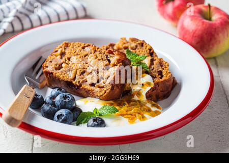 Fette di torta di frutta vegana con crema, frutti di bosco e frutto della passione, da vicino. Dessert vegano. Foto Stock