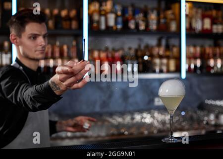 il barman sta facendo un cocktail con una bolla d'aria fumosa Foto Stock