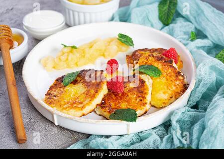 Pancake al formaggio di curd con panna acida, miele e frutti di bosco. Delizioso sciroppo con pere caramellate Foto Stock