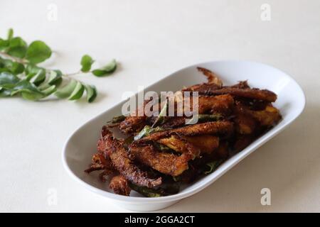 Croccante e piccante frittura di Anchovy. Acciughe marinate con spezie e fritte profonde. Piatto di pesce popolare dal Kerala chiamato Natholi fry. Foto Stock