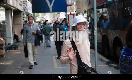 Old Chinese Man Pedestrian con Long White Beard Nathan Road è il passaggio principale in Yau ma Tai, Mongkok, Kowloon, Hong Kong, Cina Foto Stock