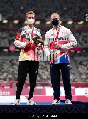 Jonnie Peacock della Gran Bretagna con la sua medaglia di bronzo accanto al vincitore della medaglia di bronzo congiunta Johannes Floors della Germania per i 100m - T64 degli uomini durante l'atletica allo Stadio Olimpico il sesto giorno dei Giochi Paralimpici di Tokyo 2020 in Giappone. Data foto: Lunedì 30 agosto 2021. Foto Stock