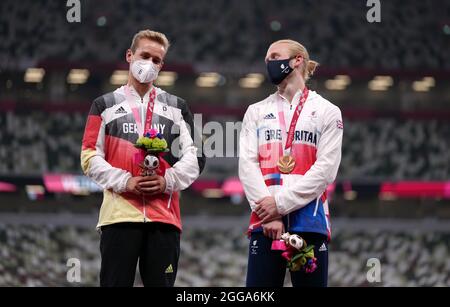 Jonnie Peacock della Gran Bretagna con la sua medaglia di bronzo accanto al vincitore della medaglia di bronzo congiunta Johannes Floors della Germania per i 100m - T64 degli uomini durante l'atletica allo Stadio Olimpico il sesto giorno dei Giochi Paralimpici di Tokyo 2020 in Giappone. Data foto: Lunedì 30 agosto 2021. Foto Stock