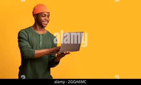 Ritratto del giovane uomo africano Americano con computer portatile in mano Foto Stock