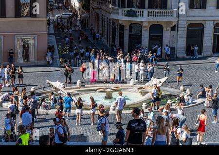 ROMA ITALIA, REGNO UNITO. 30 ago 2021. Grandi folle di turisti si riuniscono intorno alla Fontana della barca (Fontana della Barcaccia) in fondo a Piazza di Spagna in una giornata calda a Roma. Il Ministero della Sanità italiano ha annunciato che iti scaricherà la quarantena di cinque giorni per i viaggiatori provenienti dal Regno Unito che sono completamente vaccinati e mostreranno un test negativo di covid-19 dal 31 agosto. Credit: amer Ghazzal/Alamy Live News Foto Stock