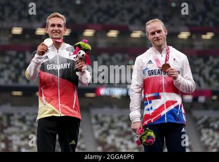 Jonnie Peacock della Gran Bretagna con la sua medaglia di bronzo accanto al vincitore della medaglia di bronzo congiunta Johannes Floors della Germania per i 100m - T64 degli uomini durante l'atletica allo Stadio Olimpico il sesto giorno dei Giochi Paralimpici di Tokyo 2020 in Giappone. Data foto: Lunedì 30 agosto 2021. Foto Stock