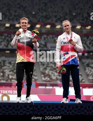 Jonnie Peacock della Gran Bretagna con la sua medaglia di bronzo accanto al vincitore della medaglia di bronzo congiunta Johannes Floors della Germania per i 100m - T64 degli uomini durante l'atletica allo Stadio Olimpico il sesto giorno dei Giochi Paralimpici di Tokyo 2020 in Giappone. Data foto: Lunedì 30 agosto 2021. Foto Stock