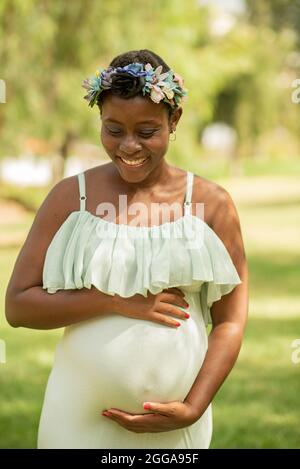Felice afroamericana donna in abito bianco. Foto Stock