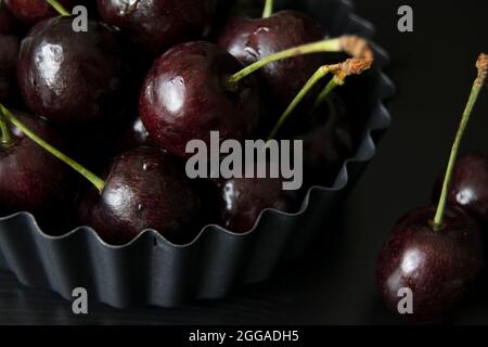 Ciliegie nere succose in un piatto di flan flan Foto Stock