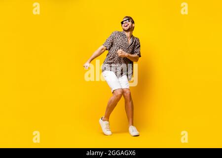 Foto a tutta lunghezza di cute funky giovane gentleman vestito stampa occhiali da stampa danza sorridente isolato colore sfondo giallo Foto Stock