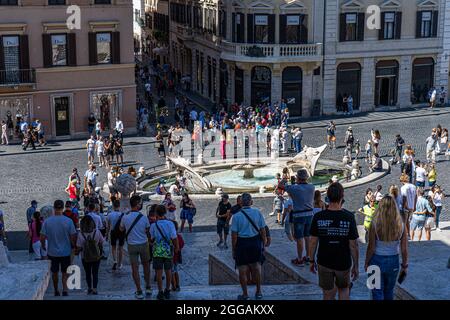 ROMA ITALIA, REGNO UNITO. 30 ago 2021. Grandi folle di turisti si riuniscono intorno alla Fontana della barca (Fontana della Barcaccia) in fondo a Piazza di Spagna in una giornata calda a Roma. Il Ministero della Sanità italiano ha annunciato che iti scaricherà la quarantena di cinque giorni per i viaggiatori provenienti dal Regno Unito che sono completamente vaccinati e mostreranno un test negativo di covid-19 dal 31 agosto. Credit: amer Ghazzal/Alamy Live News Foto Stock