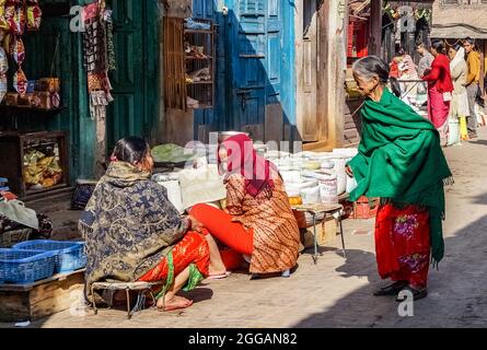 Tre donne nepalesi che parlano per strada davanti ad un negozio a Kathmandu, Nepal Foto Stock