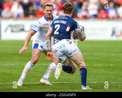 Tom Jonstone ( 2 ) di Wakefield Trinity è affrontato da Richie Myler ( 16 ) di Leeds Rhinos Foto Stock