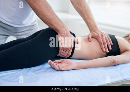 Fisioterapista maschile che fa professionale sessione di terapia manuale in ufficio medico Foto Stock