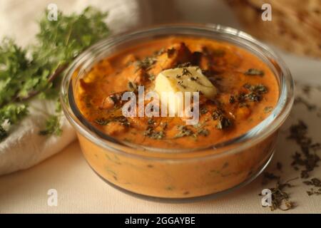 Pollo al burro fatto di pezzi di pollo grigliati cotti in salsa cremosa di pomodoro al burro servito con parotta di kerala, un pane piatto a strati fatto di Maida. THI Foto Stock