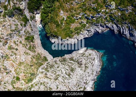 Vista aerea di una spettacolare spiaggia di una penisola di Karaburun isolata e di una piccola spiaggia nascosta, esplorata dai turisti su un motoscafo albania Foto Stock