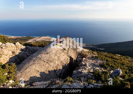 Turisti seduti su un vecchio bunker militare sul passo di Llogara con una vista incredibile verso la riviera albanese e la costa marittima, albania, europa Foto Stock