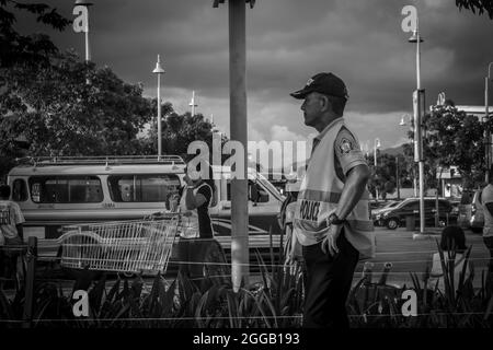 SUBIC, FILIPPINE - 09 agosto 2017: Una vista in scala grigia di un ufficiale di polizia in piedi a Olongapo City Zambales, Filippine Foto Stock