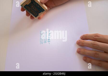 le mani della donna che mettono un timbro di imballaggio sostenibile Foto Stock