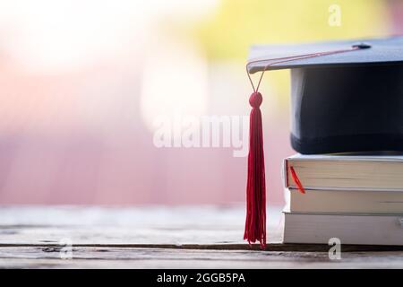 Primo piano focus selettivo di un cappello di laurea o di un mortarboard e certificato di diploma messo sul tavolo Foto Stock