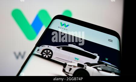 Telefono cellulare con sito web della società di guida autonoma degli Stati Uniti Waymo LLC sullo schermo di fronte al logo business. Mettere a fuoco sulla parte superiore sinistra del display del telefono. Foto Stock