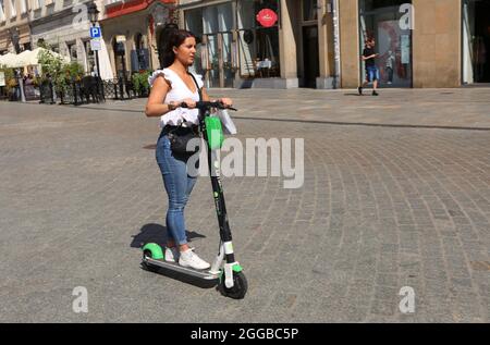 Cracovia. Cracovia. Polonia. Giovane donna che guida e scooter. Foto Stock