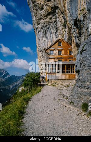 Alpi Svizzere e un ristorante di montagna sotto la scogliera Aescher vista dalla montagna Ebenalp nella regione di Appenzell in Svizzera Aescher scogliera Svizzero Foto Stock