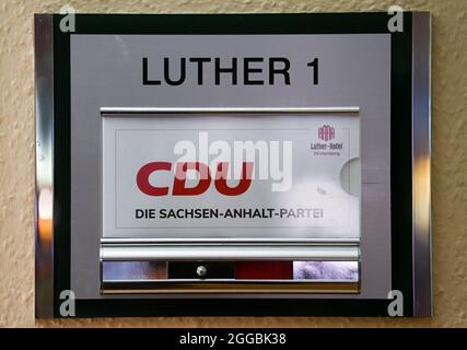 Wittenberg, Germania. 30 ago 2021. "CDU - il partito Sassonia-Anhalt" è scritto all'ingresso della conferenza regionale della CDU in una sala riunioni. Come il DOCUP, la CDU in Sassonia-Anhalt sta attualmente lasciando ai suoi membri votare per iscritto l'accordo di coalizione per l'alleanza nero-rosso-giallo. Tutti i 6075 membri hanno tempo fino al 7 settembre per votare. Credit: Hendrik Schmidt/dpa-Zentralbild/dpa/Alamy Live News Foto Stock