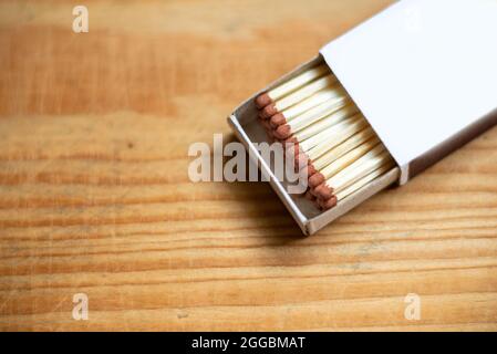 Fiammiferi di sicurezza di legno impilati in scatola di fiammiferi di cartone su background.Box di matches.Wooden table.copy space.Open box di matches.closeup. Foto Stock