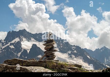 Equilibrio di pietre. Pietre equilibranti sulla parte superiore del masso. Primo piano. Equilibrio di pietre su un cielo blu e sfondo di montagne con uno spazio copia. Pietra Foto Stock