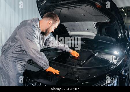 Auto Mechanic controllo auto con cofano aperto in officina auto riparazione Foto Stock