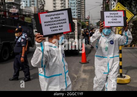 Metro Manila, Filippine. 30 agosto 2021. Gli operatori sanitari portano segnali durante una protesta per celebrare la Giornata Nazionale degli Eroi fuori dal St. Luke's Medical Center a Quezon City. Il gruppo ha invitato il governo a liberare fondi per le prestazioni e un'adeguata protezione per gli operatori sanitari che continuano a essere a rischio a causa dell'aumento dei casi COVID-19 nel paese. Credit: Majority World CIC/Alamy Live News Foto Stock