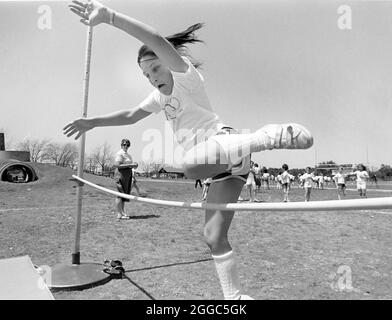 Austin Texas USA, 1991: Ragazza di terza elementare salta sopra la traversa durante la giornata di pista e campo alla scuola elementare. ©Bob Daemmrich Foto Stock